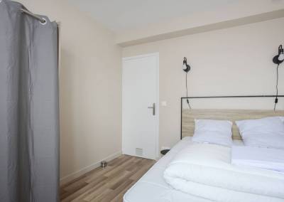 La literie avec une tête de lit métal noir et bois clair pour cette chambre, par BH-Déco, Agence d'Architecture intérieure et Décoration dans l'Essonne